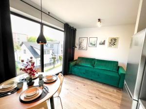 uma sala de estar com um sofá verde e uma mesa em Apartament DELUX ROZTOCZE em Tomaszów Lubelski