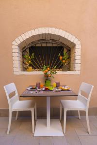 a table with two chairs and a plate of food at ELISEO PALACE TROPEA in Tropea
