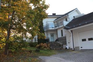 a white house with a staircase and a garage at Apartment Lumikontupa in Jyväskylä