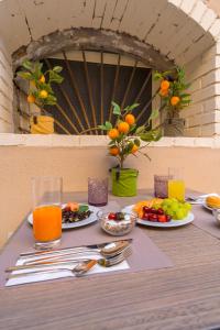 einen Tisch mit Teller mit Lebensmitteln und Obst darauf in der Unterkunft ELISEO PALACE TROPEA in Tropea