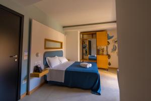 a bedroom with a blue bed and a mirror at ELISEO PALACE TROPEA in Tropea