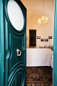 uma porta verde que leva a um quarto com uma cama em Le case di Via Patitari em Gallipoli