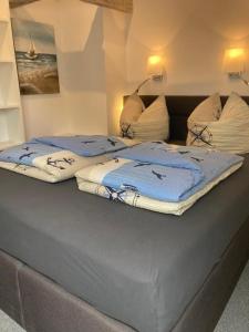 2 camas con mantas azules y blancas. en Pappelhof - Doppelhaushälfte mit Garten in Grömitz, en Grömitz