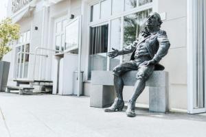 a statue of a man sitting on a bench at Best Western Hotel Kurfürst Wilhelm I. in Kassel