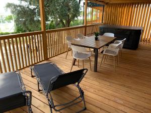 a wooden deck with a table and chairs and a grill at Luxury Mobile Houses Adria in Selce