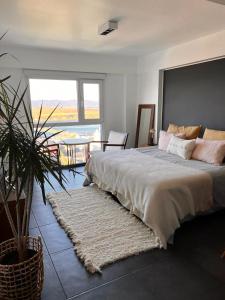 a bedroom with a large bed with a large window at LiveUshuaia Beagle View in Ushuaia