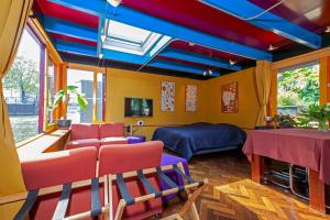 um quarto com tectos coloridos e uma cama e cadeiras em Dreamtime Houseboat em Amsterdã