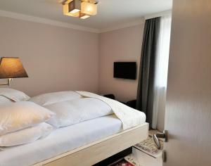 Un dormitorio con una cama con almohadas blancas y una ventana en Landhaus Stenitzer 