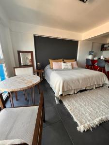 a bedroom with a bed and a table and chairs at LiveUshuaia Beagle View in Ushuaia +6 photos
