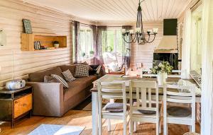 a living room with a couch and a table at Awesome Home In Brcke With Lake View in Baksjöbodarna