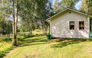 a small house with a green trash can in the yard at Nice Home In Brcke With 2 Bedrooms, Sauna And Wifi in Baksjöbodarna