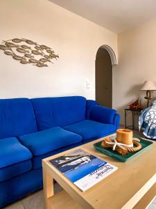 Sofá azul en la sala de estar con mesa en Venetia apartment en Porto Heli