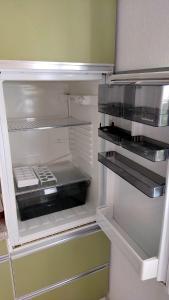 um frigorífico vazio com a porta aberta numa cozinha em *Gemütliche Ferienwohnung in perfekter Lage* em Wilsdruff