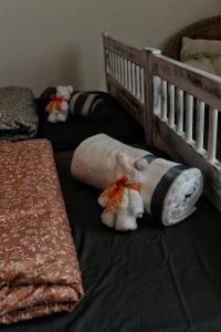 due animali di peluche sdraiati su un letto accanto a una culla di Art and Sport Pinè a Baselga di Pinè