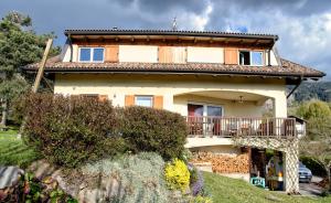 een groot huis met een balkon op een heuvel bij Art and Sport Pinè in Baselga di Pinè