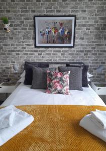 a bedroom with a brick wall and a bed with pillows at Lansdowne Simply Stay in Redruth