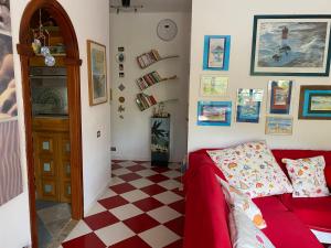- un salon avec un canapé rouge et un sol en damier dans l'établissement ARGENTARIO… tutto da scoprire, à Porto Santo Stefano