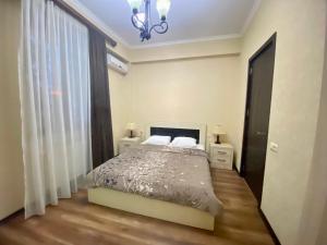 MG Apartments in Tbilisi في تبليسي: غرفة نوم بسرير وثريا
