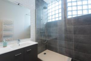La salle de bains est pourvue d'une douche et d'un lavabo. dans l'établissement Appartements centre-ville - Wifi - Cuisine tout équipée - Lave-linge, à Pau