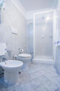 a white bathroom with a toilet and a shower at Hotel Fontana in Amalfi