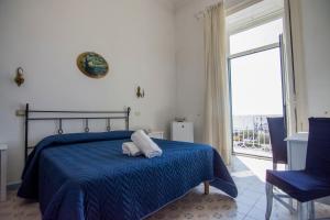 a bedroom with a bed with a blue blanket and a window at Hotel Fontana in Amalfi
