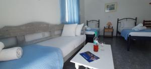 a hotel room with two beds and a table with a book at Maria's View in Ios Chora