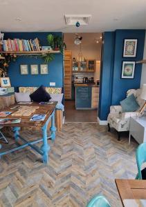 sala de estar con mesa y pared azul en Lansdowne Simply Stay, en Redruth