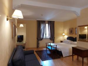 a hotel room with a bed and a couch at Phi Hotel Canalgrande in Modena