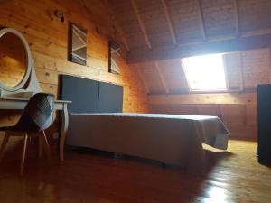 Habitación con cama, mesa y espejo. en SUPERBE CHALET AVEC PISCINE CHAUFFEE Juillet et Aout, en Saint-Manvieu-Bocage