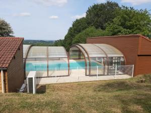 una casa con piscina y un edificio en SUPERBE CHALET AVEC PISCINE CHAUFFEE Juillet et Aout, en Saint-Manvieu-Bocage