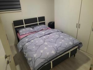 ein Schlafzimmer mit einem Bett mit lila Bettdecken und Kissen in der Unterkunft Apartman Centar Novi Grad in Bosanski Novi