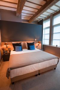- une grande chambre avec un grand lit et des oreillers bleus dans l'établissement Hotel Neuvice, à Liège