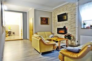 a living room with two couches and a fireplace at Góralski Pałacyk in Biały Dunajec