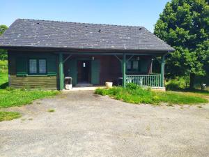 Casa pequeña con techo verde y porche en Chalet bois, en Neuville