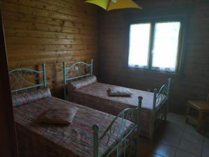 a room with two beds and a window at Chalet bois in Neuville