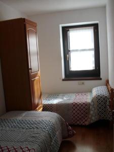 1 dormitorio con 2 camas y ventana en Apartamentos Nevados 19103IZ, en Anciles