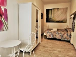 シラクーサにあるAppartamento Galateaのベッドルーム1室(ベッド1台、テーブル、椅子付)
