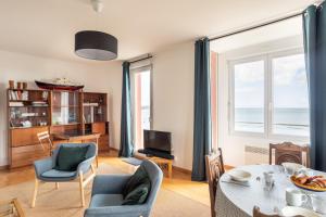 a living room with a table and chairs at L'Ar Timon in Saint-Cast-le-Guildo