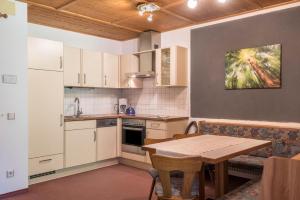 a kitchen with a table and a table and chairs at Ferienparadies Sabina Schlern in Alpe di Siusi