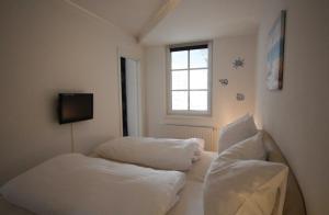 バーベにあるFerienwohnung Seestern (Ref. 128659u1)の白いベッド2台と窓が備わる客室です。