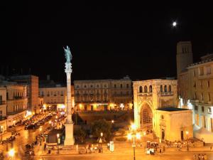 Una ciudad de noche con una estatua en el medio en Casa Dei Mercanti Town House en Lecce