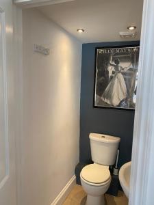 a bathroom with a toilet and a poster of a woman at 28 King Street in Margate