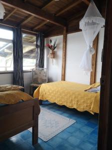 ein Schlafzimmer mit einem gelben Bett und einem Fenster in der Unterkunft Cafe del Mar Sapzurro in Zapzurro