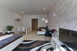 a bedroom with a bed and a living room at Atrium Apartments in Brno