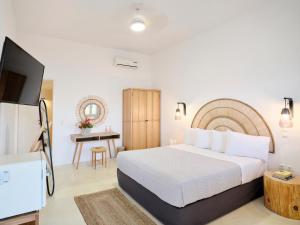 a hotel room with a bed and a television at Bonatsa Beach House in Kimolos