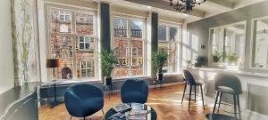 a room with chairs and a table and windows at Elf bed and breakfast in Bolsward