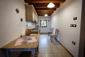 a kitchen with a table and chairs in a room at La Marmote Albergo Diffuso di Paluzza Clome in Paluzza