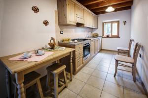 a kitchen with a wooden table and a stove top oven at La Marmote Albergo Diffuso di Paluzza Clome in Paluzza