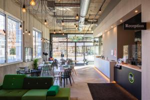 a restaurant with green furniture and tables and chairs at B&B HOTEL Basel in Basel