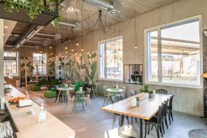 a restaurant with tables and chairs in a room at B&B HOTEL Basel in Basel